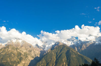 Scenic view of snowcapped mountains against blue sky