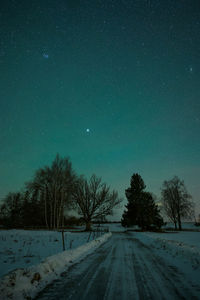 Road amidst field against sky at night