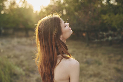 Side view of young woman looking away outdoors
