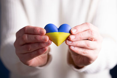 Midsection of woman holding heart shape decoration