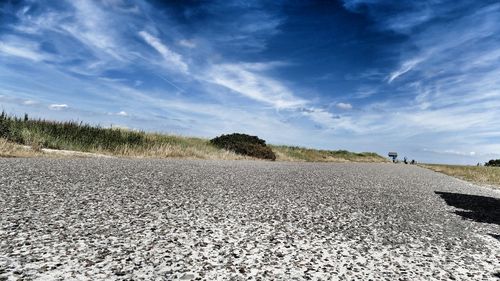 Surface level of road on field against sky