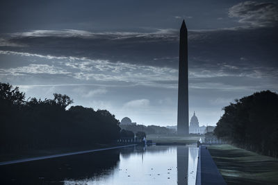 Scenic view of river by silhouette trees against sky