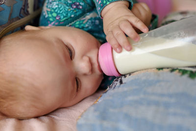 Three month old girl drinks milk from a bottle