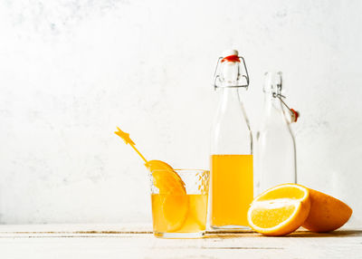 Fruits in glass on table against wall