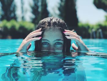 Portrait of young woman swimming in pool