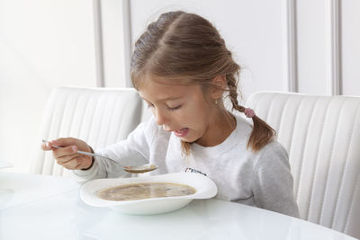 Portrait of girl looking away while sitting on plate