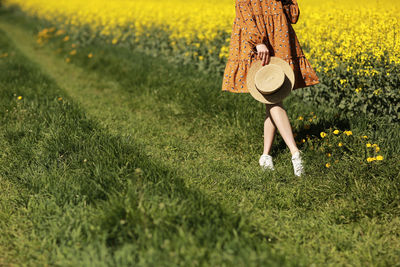 Rear view of woman standing on grassy field