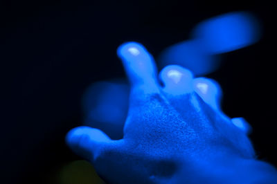 Close-up of human hand against black background