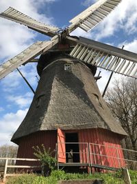 Low angle view of traditional windmill against sky