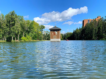 Scenic view of lake by building against sky