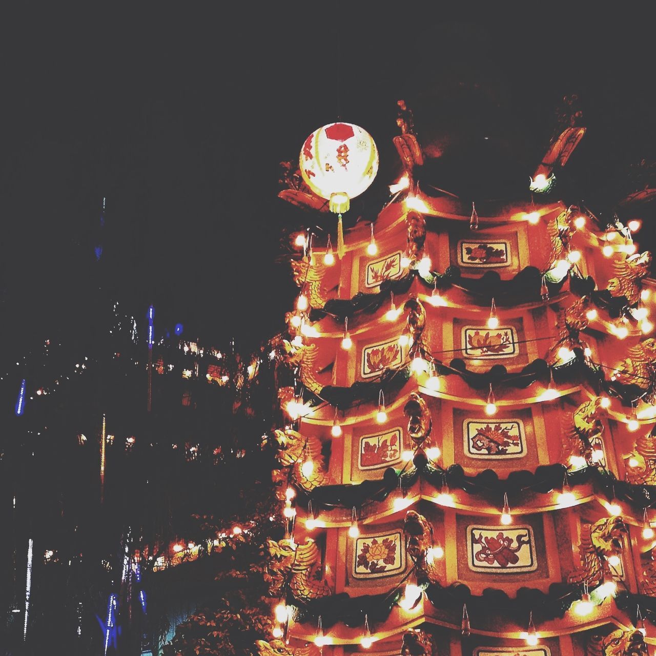 illuminated, night, low angle view, celebration, religion, tradition, christmas, place of worship, spirituality, decoration, cultures, building exterior, architecture, red, built structure, christmas decoration, lighting equipment, arts culture and entertainment, christmas tree