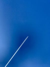 Low angle view of airplane flying against blue sky