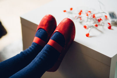 Low section of girl wearing red shoe