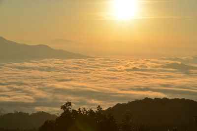 Scenic view of silhouette mountains against orange sky