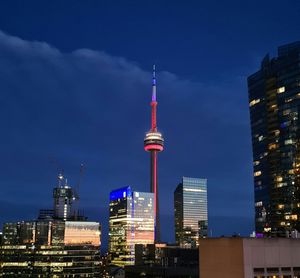 Low angle view of the cn tower and surrounding skyscrapers against the night sky