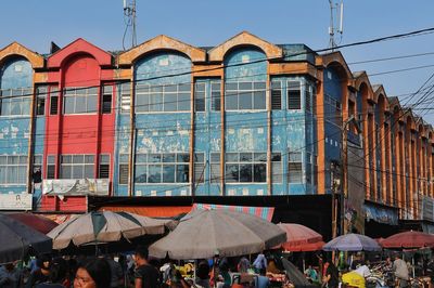 People on street against buildings in city