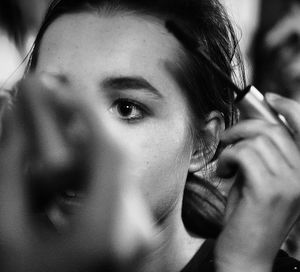 Woman applying mascara on hair