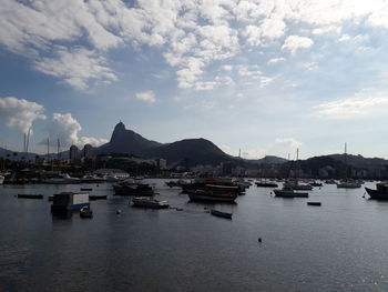 Sailboats moored in harbor against sky