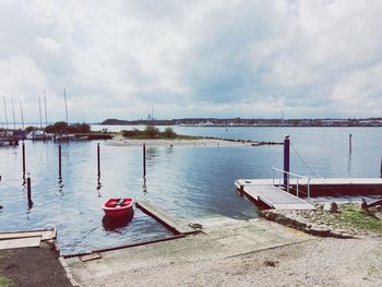 Boats in sea against cloudy sky