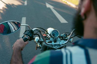 Rear view of man riding motorcycle on road