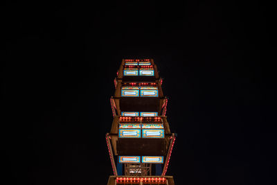 Low angle view of illuminated ferris wheel against sky at night