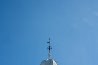 Low angle view of cross and building against blue sky