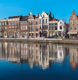 Reflection of buildings in river against blue sky