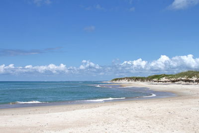 Scenic view of beach against blue sky