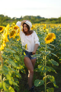 Portrait of young woman standing in sunflower field