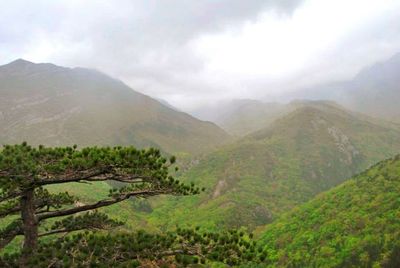 Scenic view of mountains against cloudy sky