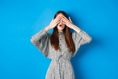 Woman standing against blue background