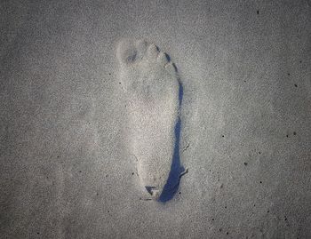 High angle view of footprints on sand at beach