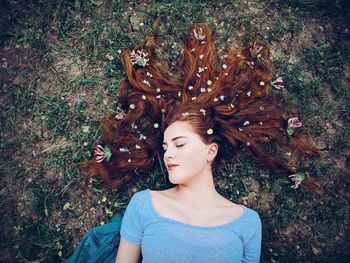 High angle view of young woman lying on field