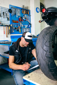 Mature mechanic examining motorcycle in garage