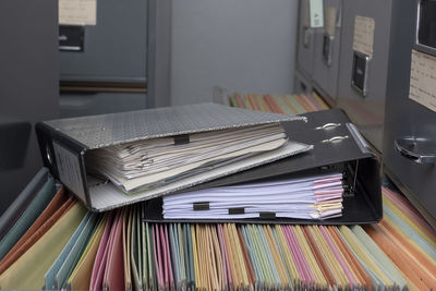 Close-up of ring binders on filing cabinet in office