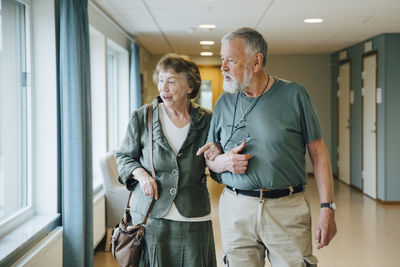 Full length of man holding camera while standing in corridor