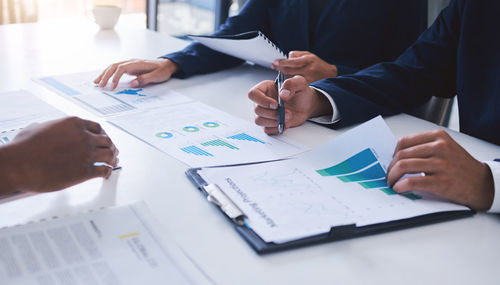 Midsection of business colleagues working on table