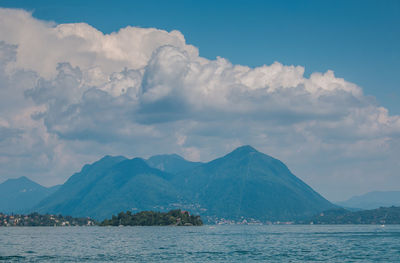 Scenic view of sea by mountains against sky