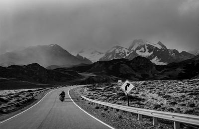 Road leading towards mountains against sky