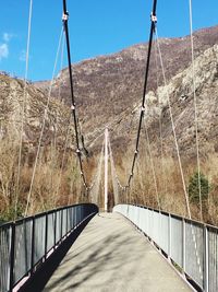 Footbridge against sky on sunny day