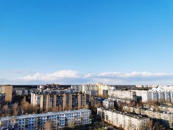 High angle view of buildings against blue sky