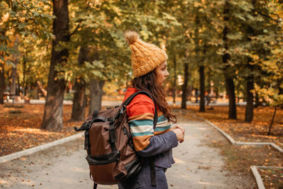 Fall travel, autumn trip, getaway, vacations, solo travel. plus size girl with backpack in  park.