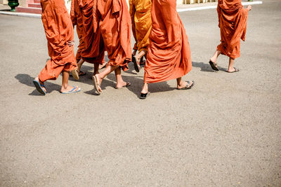 Low section of monks walking on road