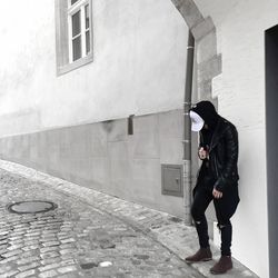 Full length of woman standing against wall