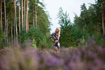 Full length of young woman walking on flower trees