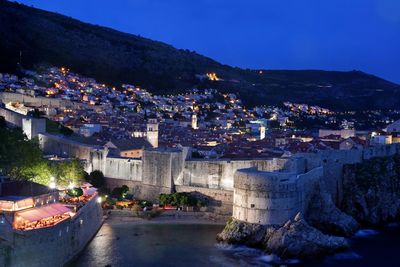 Town by mountain against clear sky at night