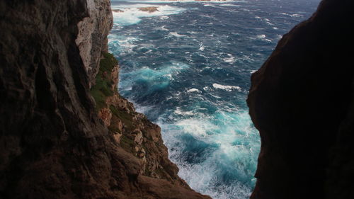 High angle view of rocky cliff and sea