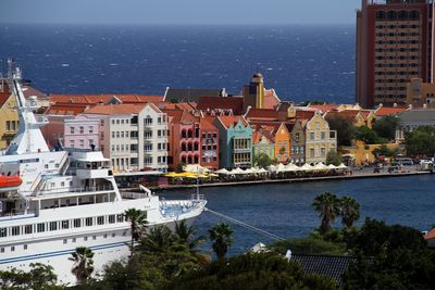 Cityscape by sea against sky