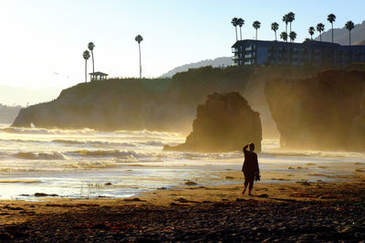 Man standing on beach against clear sky