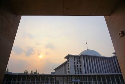 Low angle view of buildings against sky during sunset